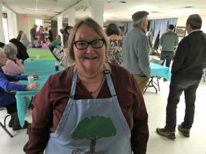 Gwen johnson smiles in front of a crowd at hemphill community center in letcher county, ky.