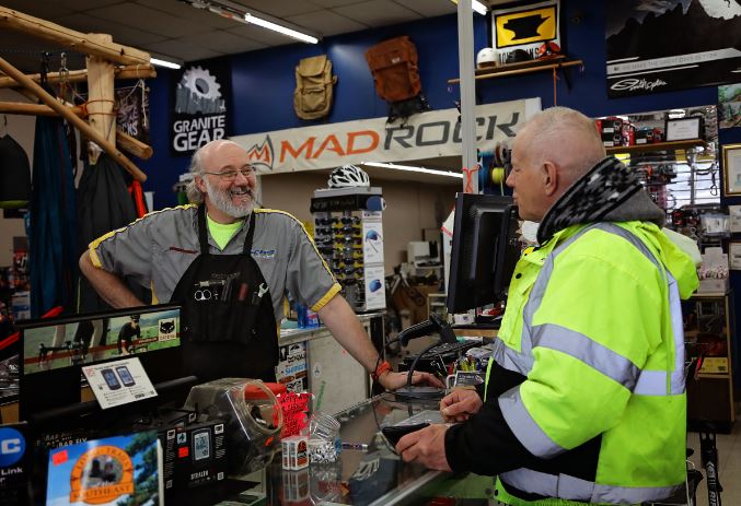 Mike stands at the cash register with a customer inside his outdoor store in Richmond, Kentucky.