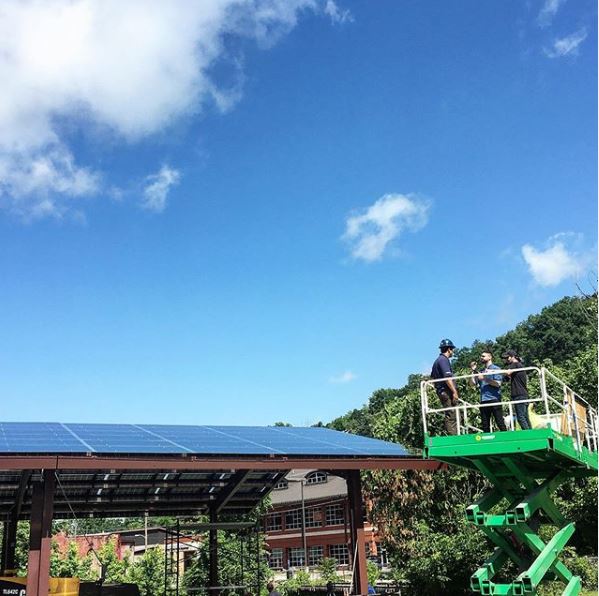 A cherrylift takes a group of people above solar panels in eastern kentucky. many appalachian communities are going solar